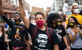 Masked protesters raising their fists at a Black Lives Matter march