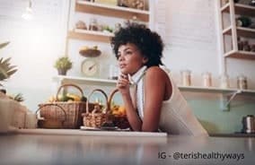 A woman leaning on a cafe counter, looking into the distance